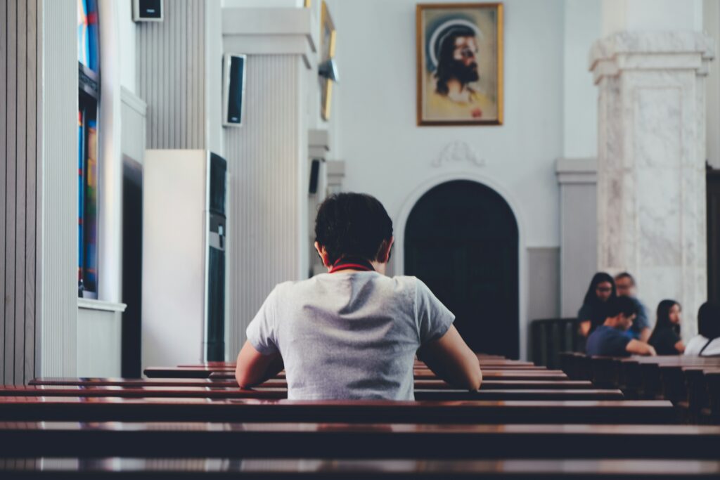 Japanese church interior with a lone man praying in empty pews, symbolizing the need for spiritual renewal and next-generation leaders in Japan’s church